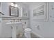 Small bathroom features a classic pedestal sink, tile floors, and a toilet at 1299 Harding Street, Winter Park, FL 32789