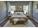Cozy bedroom with hardwood floors, two windows, and a wooden frame bed with a gray comforter at 16670 Sw 29Th Terrace Rd, Ocala, FL 34473