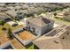 Aerial view of fenced backyard with fire pit and swing set and house with solar panels at 542 Patton Loop, Bartow, FL 33830