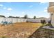 View of spacious backyard with white vinyl fence, fire pit, swing set and concrete paver extension at 542 Patton Loop, Bartow, FL 33830
