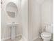 Bathroom featuring a modern pedestal sink, toilet, and neutral color palette at 542 Patton Loop, Bartow, FL 33830