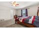 Bright bedroom with wooden bed frame, a window with curtains, and carpet flooring at 542 Patton Loop, Bartow, FL 33830