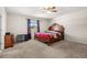 Comfortable bedroom with wooden furniture, purple curtains, and soft carpet flooring at 542 Patton Loop, Bartow, FL 33830