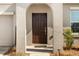 Close up of dark wood front door with covered porch, welcome sign and modern hardware at 542 Patton Loop, Bartow, FL 33830