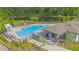 Community pool with lounge chairs, a covered area, and a lake in the background at 570 Pink Ibis Bnd, St Cloud, FL 34772