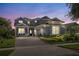 Charming two-story home with landscaped yard and paver driveway at twilight at 7837 Bostonian Dr, Winter Garden, FL 34787