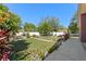 Landscaped backyard featuring a grassy lawn, white fencing, patio, and mature trees at 9301 Echo Run, Orlando, FL 32817