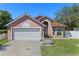 Charming single-Gathering home featuring a two-car garage and beautifully landscaped front yard, complemented by a sunny blue sky at 9301 Echo Run, Orlando, FL 32817