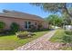 Exterior side view of home showcasing brick walkway, garden, and manicured lawn at 9301 Echo Run, Orlando, FL 32817