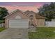 A beautiful front exterior with a two-car garage and lush green lawn at 9301 Echo Run, Orlando, FL 32817