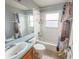 Cozy bathroom featuring a tub-shower combination with a curtain, a toilet, a sink, and a mirror at 1002 Courtland St, Orlando, FL 32804
