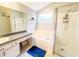 Bright bathroom featuring a vanity, large mirror, soaking tub, and glass-enclosed shower at 1002 Courtland St, Orlando, FL 32804