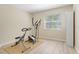 Bright bedroom with exercise equipment, neutral walls, light flooring, and natural light from the large window at 110 Tedworth Ct, Longwood, FL 32779