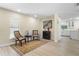 Cozy living room with chairs, wood-look floors, and a view into the white kitchen at 110 Tedworth Ct, Longwood, FL 32779