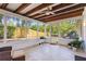 Enclosed screened porch with ceiling fan, outdoor grill, tile flooring, wooden beams and natural views at 110 Tedworth Ct, Longwood, FL 32779