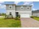 Lovely two-story home with a manicured lawn, brick-paved driveway, and an attached garage at 16448 Winding Preserve Cir, Clermont, FL 34714