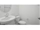 Clean powder room with a pedestal sink and a modern round mirror at 16484 Silver Brook Way, Winter Garden, FL 34787