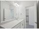 Bright bathroom featuring a large mirror, modern vanity, and an open doorway to the laundry area at 16484 Silver Brook Way, Winter Garden, FL 34787