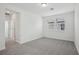 Bright bedroom with gray carpet, two windows, and a doorway leading to another room at 16484 Silver Brook Way, Winter Garden, FL 34787