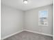 A cozy bedroom with neutral walls, carpeted floor, and a window offering natural light at 16484 Silver Brook Way, Winter Garden, FL 34787