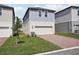 View of a two-story home with a well-maintained lawn and brick driveway at 16484 Silver Brook Way, Winter Garden, FL 34787