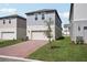 View of a charming two-story home with a well-maintained lawn and brick driveway at 16484 Silver Brook Way, Winter Garden, FL 34787