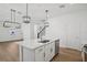 Open kitchen with a large island, stainless steel appliances, and modern pendant lights at 16484 Silver Brook Way, Winter Garden, FL 34787