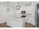 Modern kitchen with a center island, stainless steel appliances, and stylish pendant lighting at 16484 Silver Brook Way, Winter Garden, FL 34787