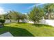 Spacious backyard featuring lush green grass, a basketball hoop, and a white fence for added privacy at 16843 Cedar Run Dr, Orlando, FL 32828