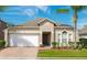 Charming single-story home with a well-manicured lawn, brick driveway, and attached two-car garage at 16843 Cedar Run Dr, Orlando, FL 32828