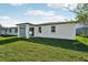 Green backyard with a white, modern single-story home and well-maintained lawn at 4709 Jasmine Cir, Leesburg, FL 34748