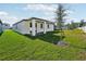 Green backyard with a white, modern single-story home and well-maintained lawn at 4709 Jasmine Cir, Leesburg, FL 34748