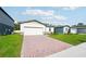 Attractive single-story house with a brick driveway, well-manicured lawn, and clean, neutral facade at 4709 Jasmine Cir, Leesburg, FL 34748