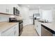 Stylish kitchen with stainless steel appliances, white cabinets and countertops, and tile flooring at 4709 Jasmine Cir, Leesburg, FL 34748