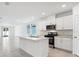 Modern kitchen with white cabinets, stainless steel appliances, and a center island with sink at 4709 Jasmine Cir, Leesburg, FL 34748