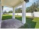 Covered brick patio with white pillars and a view of the fenced backyard at 4709 Jasmine Cir, Leesburg, FL 34748