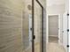 Elegant shower featuring decorative tiles and a frameless glass enclosure, leads to closet at 5133 Passion Flower Way, Winter Garden, FL 34787