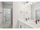 Double vanity bathroom with quartz countertop, stylish mirrors, and walk-in shower at 5133 Passion Flower Way, Winter Garden, FL 34787