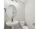 Powder room featuring a pedestal sink, modern fixtures and a sleek oval mirror at 5133 Passion Flower Way, Winter Garden, FL 34787