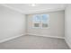 Neutral bedroom featuring plush carpeting and natural light from the windows at 5133 Passion Flower Way, Winter Garden, FL 34787