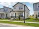 Two-story home featuring a covered front porch, manicured lawn, and a light gray exterior with a view at 5133 Passion Flower Way, Winter Garden, FL 34787