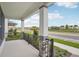 Covered front porch with beautiful stone pillars, black railing, landscaping and neighborhood street view at 5133 Passion Flower Way, Winter Garden, FL 34787