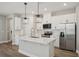 Bright kitchen boasts white cabinetry, stainless steel appliances, and an island with a sink at 5133 Passion Flower Way, Winter Garden, FL 34787