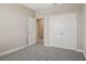 A carpeted bedroom has a double door closet and an open door to another room at 5139 Passion Flower Way, Winter Garden, FL 34787
