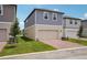 Two-story home with blue siding, neutral accents, and a brick driveway leading to a garage at 5139 Passion Flower Way, Winter Garden, FL 34787
