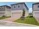 Two-story home with blue siding, neutral accents, and a brick driveway leading to a garage at 5139 Passion Flower Way, Winter Garden, FL 34787