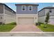 Two-story home with blue siding, neutral accents, and a brick driveway leading to a garage at 5139 Passion Flower Way, Winter Garden, FL 34787
