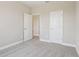 An open carpeted bedroom features white trim, neutral paint, and two entry doors at 5217 Passion Flower Way, Winter Garden, FL 34787