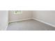 A carpeted bedroom has a window with a pleasant view and base trim at 5217 Passion Flower Way, Winter Garden, FL 34787