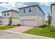 Two-story home with blue siding, a one car garage, and a brick paver driveway at 5235 Passion Flower Way, Winter Garden, FL 34787